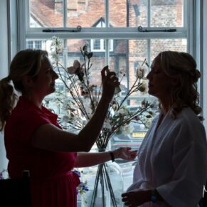 The bride having her hair sprayed in the window at the Kings Chapel's cottage in Old Amersham on her wedding day