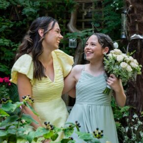 Two young wedding guests giggling away in the gardens at the cottage next door to the Kings Chapel in Old Amersham