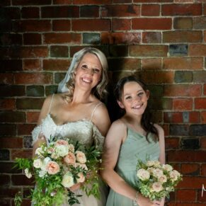 The bride with her bridesmaid captured with some dramatic lighting against an old brick wall at her Kings Chapel Old Amersham wedding