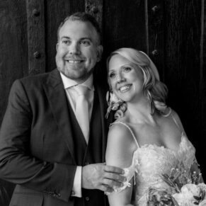 The newlyweds captured on their wedding day against the historic street entrance doorway to The Kings Chapel in Old Amersham