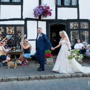 The bride and groom take a stroll in the High Street with the regular drinkers looking on at their Kings Chapel Old Amersham wedding