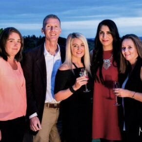 Buckinghamshire events photography of a relaxed sunset pose of five delegates on the roof terrace at Cliveden House