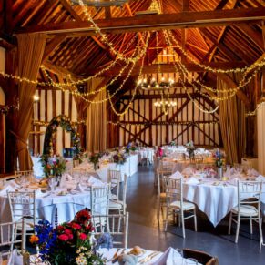 Photography of atmospheric barn venue interior all set for the wedding breakfast at this fabulous Buckinghamshire venue
