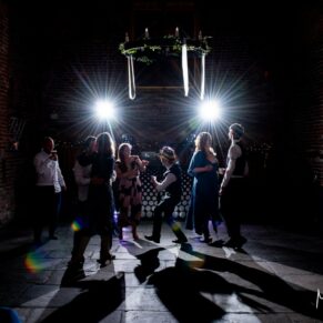 Dramatic dance floor photography of the wedding guests enjoying the vibe inside the historic tithe barn at this fabulous Buckinghamshire location