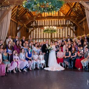 Photography of all the guests in one large group pose inside the historic tithe barn at this fabulous Buckinghamshire location just prior to the wedding breakfast