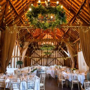 Atmospheric interior photography of the historic tithe barn interior at this stunning Buckinghamshire location just prior to the wedding breakfast