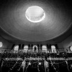 Artistic black and white photography of the bride and groom on the chapel balcony at their historic Buckinghamshire wedding venue