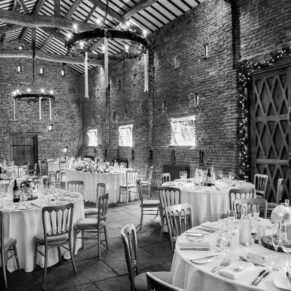Dramatic black and white photography of Buckinghamshire barn interior pre wedding breakfast