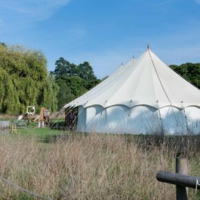 Buckinghamshire photography of a summer festival style wedding marquee in a grass meadow setting