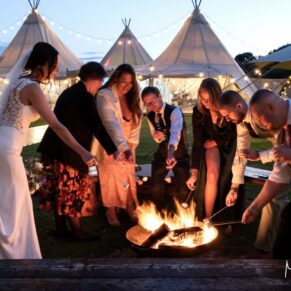 Buckinghamshire marquee wedding photography of the fire pit at dusk, whilst capturing the festival tipi in the background