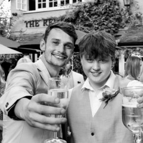 Relaxed photography pose of the groom with his son captured during the wedding drinks reception at his Buckinghamshire pub venue