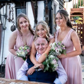 Relaxed photography pose of the groom with the bridesmaids captured during the wedding drinks reception at this Buckinghamshire pub