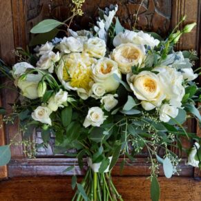 Photography of a striking white bouquet on a carved antique wooden chair at this Buckinghamshire pub wedding