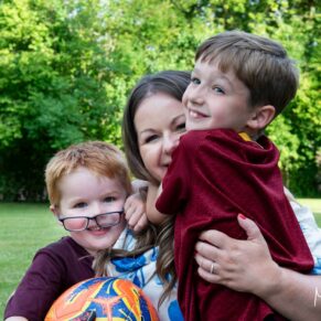 Photography of giggling pageboys being hugged by their mum at this Buckinghamshire pub wedding