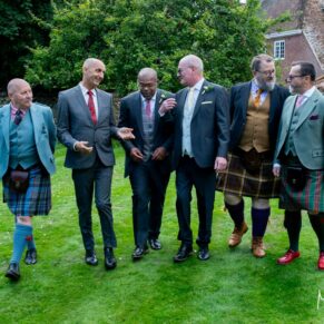 Photography of the newlyweds and the lads walking in the gardens at their Badgemore Park wedding in Oxfordshire