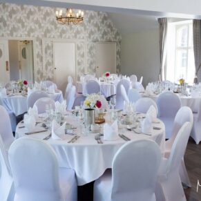 Photography of the white themed striking wedding breakfast room interior at Badgemore Park in Oxfordshire