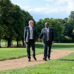 Photography of the newlyweds walking through the extensive grounds at their Badgemore Park wedding reception in Oxfordshire