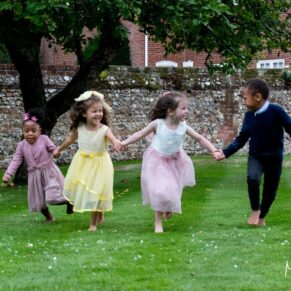 Photography of the giggling children running full pelt at the camera during this Badgemore Park wedding reception in Oxfordshire