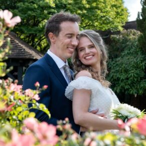 Photography of the bride and groom posing for a romantic portrait in the beautiful gardens at their Fredrick's Hotel wedding