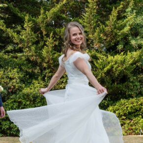 Photography of the bride spinning around with her gown blowing out in the gardens at her Fredrick's Hotel wedding