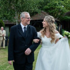Photography of the bride and her father walking across the lawn at Fredrick's Hotel in Maidenhead on her wedding day