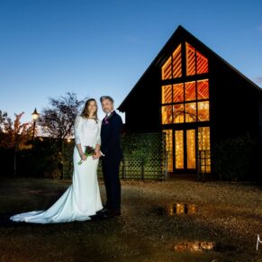 Winters Tale Country Barn wedding venue in Buckinghamshire with floodlighting used to backlight the silhouetted bride and groom for this photography capture