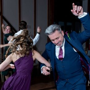 Winters Tale Country Barn wedding photography of the groom enjoying an energetic dance with the bridesmaid