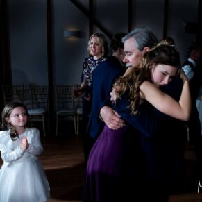 Winters Tale Country Barn wedding photography of the bride's father hugging the bridesmaid on the dance-floor