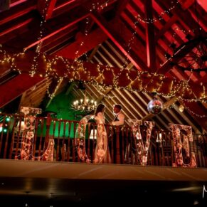 Winters Tale Country Barn wedding photography of the newlyweds on the indoor balcony with dramatic backlighting after nightfall in the barn