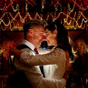Winters Tale Country Barn wedding photography of the newlyweds with dramatic backlighting after nightfall in the barn