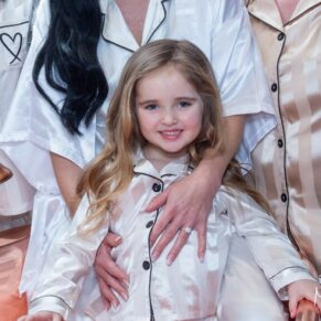 Relaxed flower girl photography taken pre ceremony as she enjoys a hug from the bridesmaids at this Crazy Bear Hotel winter wedding in Stadhampton